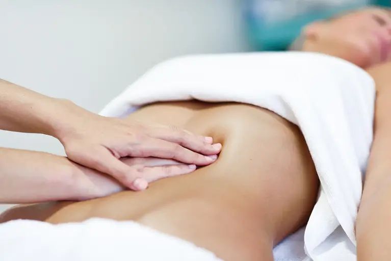 Hands massaging female abdomen.Therapist applying pressure on be